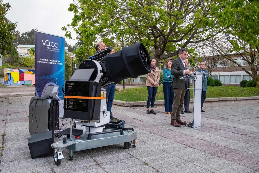 El conselleiro Rom&aacute;n Rodr&iacute;guez interviene durante la inauguraci&oacute;n de la infraestructura, junto al equipo investigador, con el sistema &oacute;ptico preparado para comunicaciones cu&aacute;nticas en primer plano.