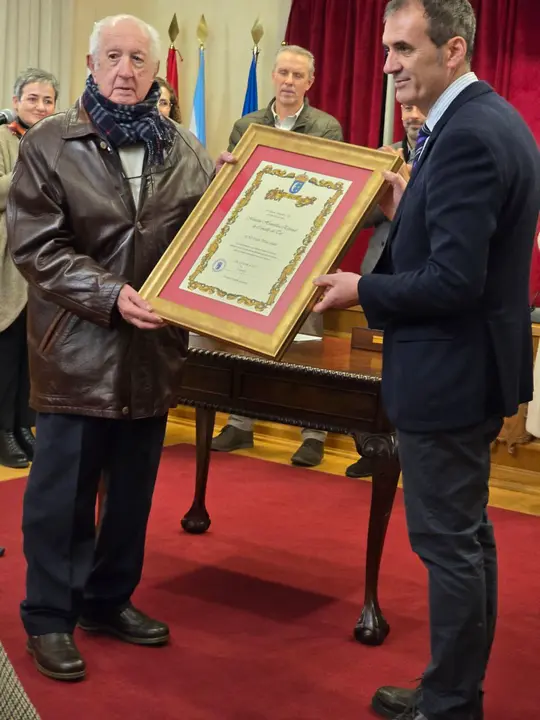 Enrique Cabaleiro y Carlos Fonterosa sostienen la  "Mención Honorífica Especial" en reconocimiento a la dilatada trayectoria de Carlos Fonterosa  por su apoyo y promoción de la actividad social, comercial y cultural de la ciudad.