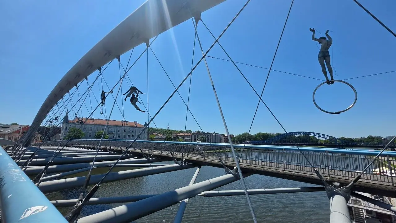 Las figuras acrob&aacute;ticas suspendidas sobre la pasarela del padre Bernatek acompa&ntilde;an el recorrido entre Kazimierz y Podg&oacute;rze, dos barrios unidos por la historia y la memoria.