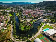 Vista a&eacute;rea de Arcos de Valdevez, com o centro urbano envolvido pelo rio Vez, evidenciando a integra&ccedil;&atilde;o entre patrim&oacute;nio, natureza e espa&ccedil;os de lazer no concelho.