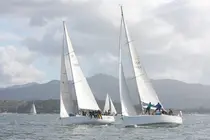 El Bon III y el ESP 10084 en plena maniobra durante la regata inaugural, con las R&iacute;as Baixas como tel&oacute;n de fondo.