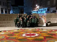 Integrantes de la Asociaci&oacute;n de Alfombristas do Corpus Christi de Ponteareas posan junto a la alfombra floral realizada en la Plaza de San Ram&oacute;n, en O Carballi&ntilde;o.