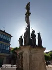Cruceiro do Sant&iacute;simo Cristo dos Aflixidos, singular peza de 1899 &uacute;nica en Galicia polas s&uacute;as alegor&iacute;as profanas &mdash;Industria, Agricultura, Artes e Xustiza&mdash; representadas en figuras femininas.