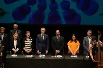 Representantes da Real Academia Galega e autoridades asistentes ao pleno extraordinario do D&iacute;a das Letras Galegas 2026, dedicado &aacute; escritora e xornalista Bego&ntilde;a Caama&ntilde;o, durante a celebraci&oacute;n no Teatro Principal de Santiago de Compostela.