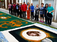 Vecinos y voluntarios posan junto a uno de los tapices florales elaborados para la festividad del Corpus Christi en Ponte de Lima. La implicaci&oacute;n de generaciones de limianos ha permitido conservar una tradici&oacute;n centenaria que cada a&ntilde;o transforma las calles de la villa en aut&eacute;nticas obras de arte ef&iacute;meras. TAPETES DA R&Uacute;A DO SOUTO.