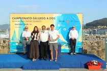 Carlota Hern&aacute;ndez y Esteban Mart&iacute;nez de la Colina reciben sus trofeos como campeones absolutos y de la categor&iacute;a mixta J80 del Campeonato Gallego A Dos, celebrado en Baiona.