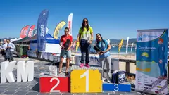 Podio femenino de la C&iacute;es-Baiona: Sheila S&aacute;nchez Castillo, en el centro, celebra la victoria en la categor&iacute;a absoluta femenina, acompa&ntilde;ada por las otras dos integrantes del podio, tras completar una de las pruebas m&aacute;s exigentes de nataci&oacute;n en aguas abiertas.