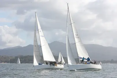 El Bon III y el ESP 10084 en plena maniobra durante la regata inaugural, con las R&iacute;as Baixas como tel&oacute;n de fondo.