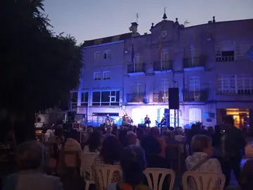 O p&uacute;blico enche a Praza do Mestre Cervi&ntilde;o para asistir ao concerto de Mar&iacute;a do Ceo, coa Casa do Concello de Covelo como pano de fondo.