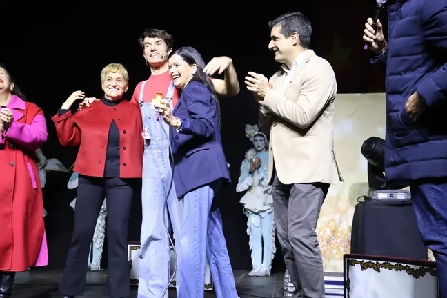 A alcaldesa de Mos, Nidia Arévalo, xunto ao director xeral de Comercio e Consumo, Gabriel Alén, e membros de Cantajuego durante o multitudinario acendido do Nadal no Pazo de Mos.