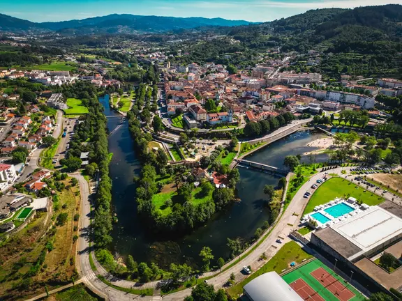 Vista a&eacute;rea de Arcos de Valdevez, com o centro urbano envolvido pelo rio Vez, evidenciando a integra&ccedil;&atilde;o entre patrim&oacute;nio, natureza e espa&ccedil;os de lazer no concelho.