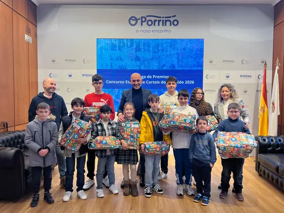 El alcalde Alejandro Lorenzo, junto a la concejala Carolina Gonz&aacute;lez y los premiados del Concurso Escolar de Carteles del Entroido do Porri&ntilde;o 2026, durante el acto celebrado en la Sala de Comunicaci&oacute;ns del Concello.