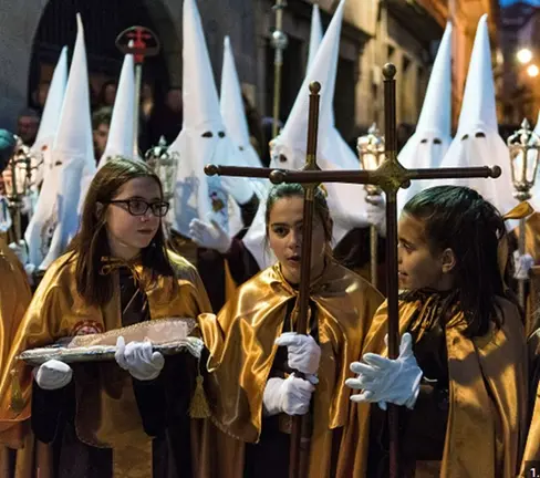 Miembros de una cofrad&iacute;a participan en una procesi&oacute;n de Semana Santa en Cangas, con los tradicionales h&aacute;bitos y estandartes recorriendo las calles del municipio.