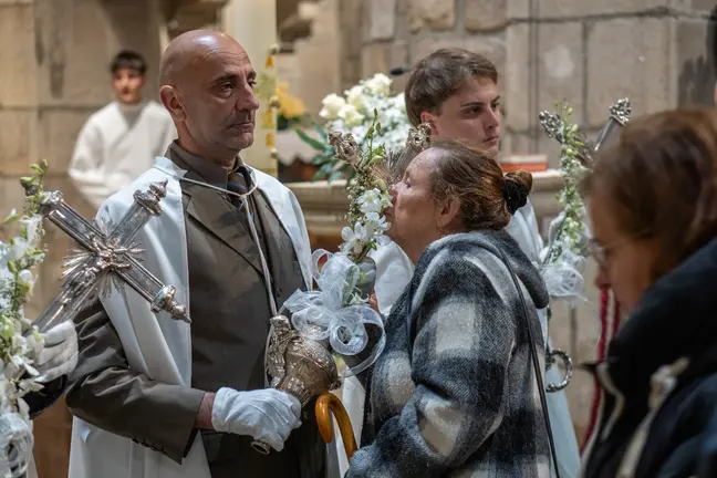 Una fiel besa una de las varas procesionales durante un acto de la Semana Santa en Ponte de Lima, en un gesto de devoci&oacute;n y tradici&oacute;n dentro del templo.
