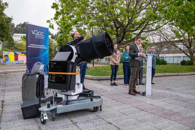El conselleiro Rom&aacute;n Rodr&iacute;guez interviene durante la inauguraci&oacute;n de la infraestructura, junto al equipo investigador, con el sistema &oacute;ptico preparado para comunicaciones cu&aacute;nticas en primer plano.