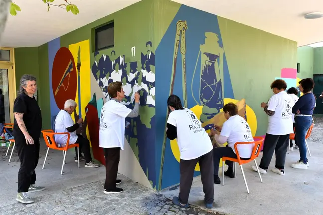 Vecinos de Verdoejo, en su mayor&iacute;a participantes del programa de envejecimiento activo, trabajan en la creaci&oacute;n del mural comunitario del Centro Cultural, una obra colectiva que recoge la memoria y la identidad local con motivo del 25 de Abril.