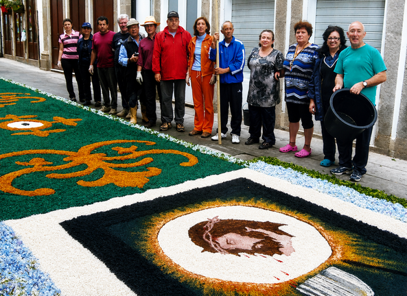Vecinos y voluntarios posan junto a uno de los tapices florales elaborados para la festividad del Corpus Christi en Ponte de Lima. La implicaci&oacute;n de generaciones de limianos ha permitido conservar una tradici&oacute;n centenaria que cada a&ntilde;o transforma las calles de la villa en aut&eacute;nticas obras de arte ef&iacute;meras. TAPETES DA R&Uacute;A DO SOUTO.