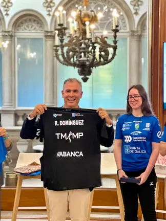 Rafa Dom&iacute;nguez recibe una camiseta conmemorativa del Club de Tenis de Mesa Monte Porreiro durante el acto de homenaje al equipo femenino tras su ascenso a la &eacute;lite del tenis de mesa espa&ntilde;ol.