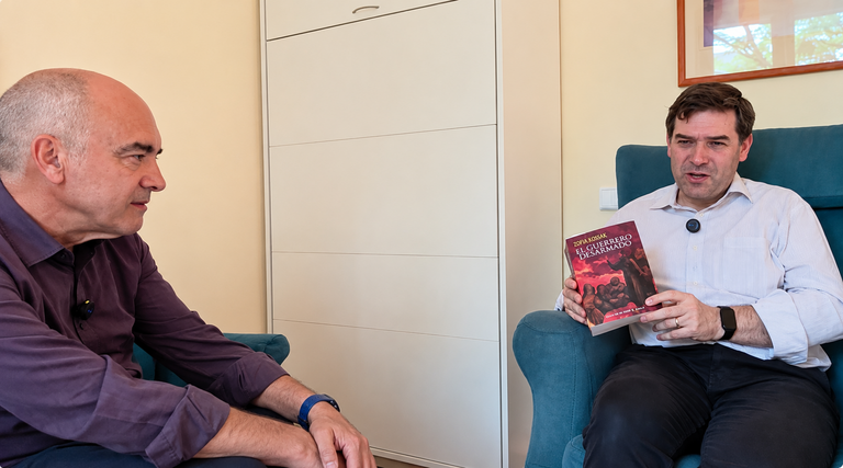 Roberto Ledo, director de Diario Luso-Galaico (DL-G), entrevista al traductor y editor Higinio Paterna, quien muestra un ejemplar de El Guerrero Desarmado, una de las obras m&aacute;s representativas de la escritora polaca Zofia Kossak, recientemente publicada en espa&ntilde;ol por la editorial Top S&aacute;rmata.