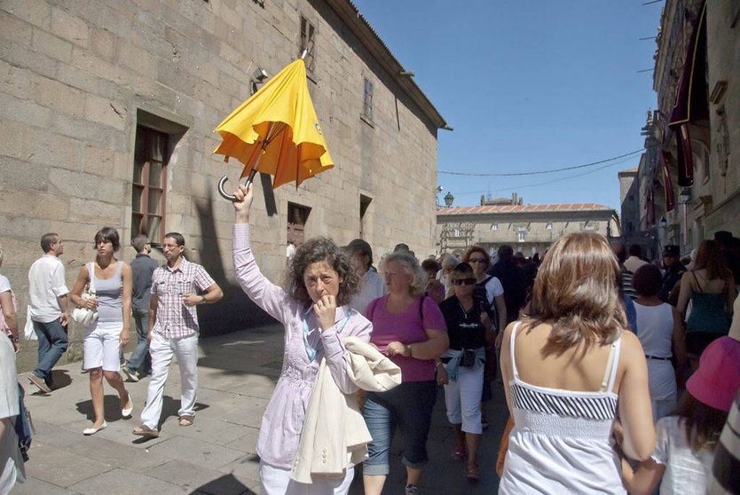 Un guía turístico dirige a un grupo de visitantes de Santiago de Compostela. 