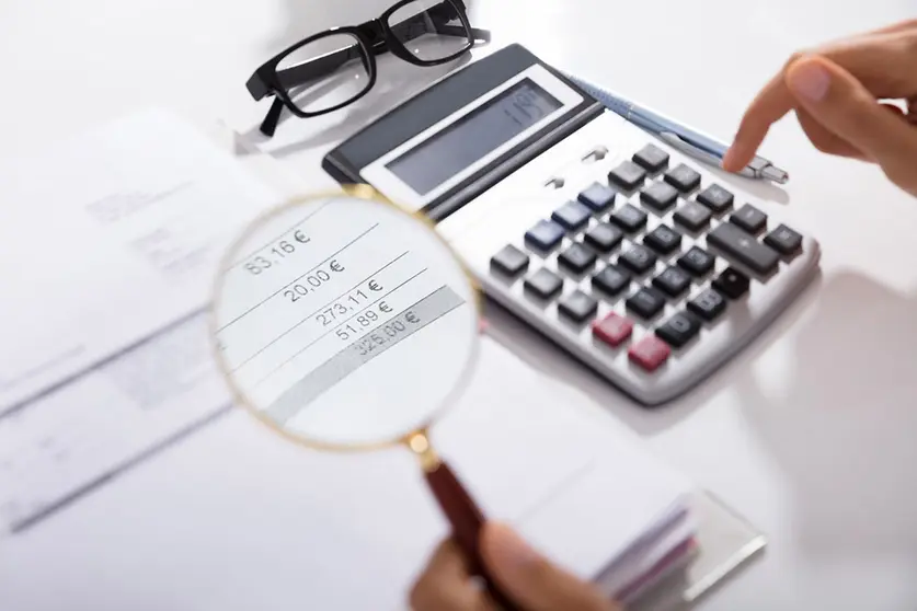Photo Of Businesswoman Analyzing Invoice With Magnifying Glass