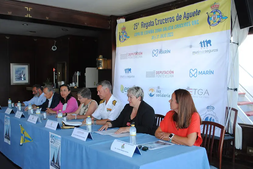 Mesa presentación regata , de izquierda a derecha, 
presidente en funciones de la Real Federación Gallega de Vela, Manuel Villaverde Fernández; presidente de la Autoridad Portuaria de Marín y Ría de Pontevedra, José Benito Suárez Costa; alcaldesa de Marín, María Ramallo; presidenta del Club, Mª del Carmen de la Puente; Comandante-Director de la Escuela Naval Militar, capitán de navío Pedro Cardona Suanzes; diputada provincial de Cohesión Social, Olga María García Ballesteros y la comodora del Club, Celina Torrado,