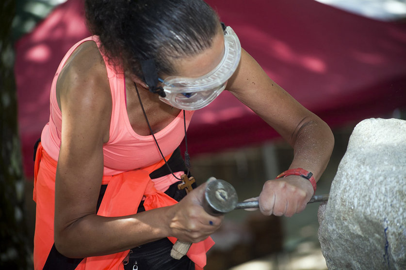Una artesana tallando piedra durante un tradicional festival público de talla de piedra, cultura española en Parga, Lugo.