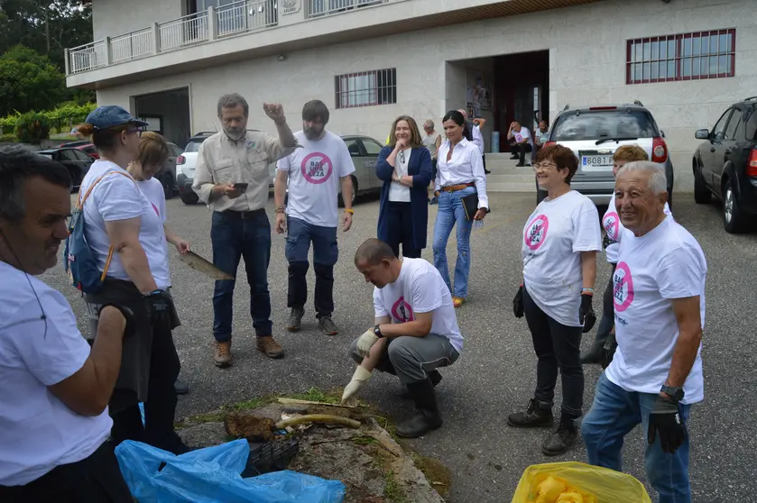 Voluntarios y autoridades de Mos, comprometidos en la limpieza del Rejo das Laxes, exhiben las bolsas repletas de residuos recogidos durante la campaña "1m² contra la basuraleza".