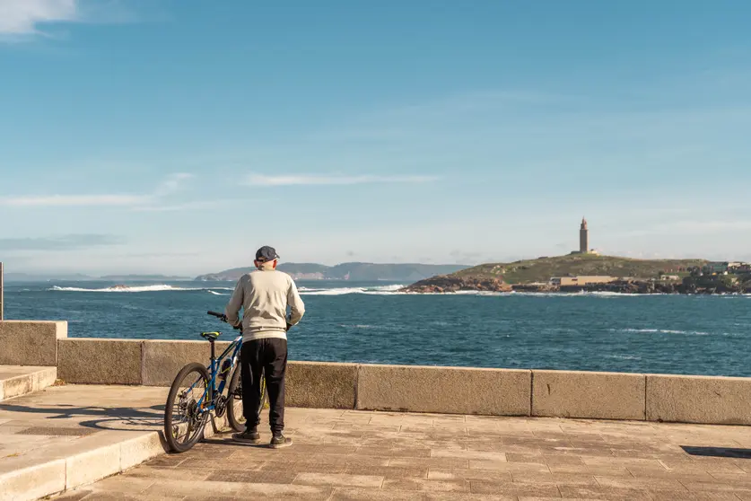 Un ciclista disfruta de las vistas de la Torre de Hércules en A Coruña.