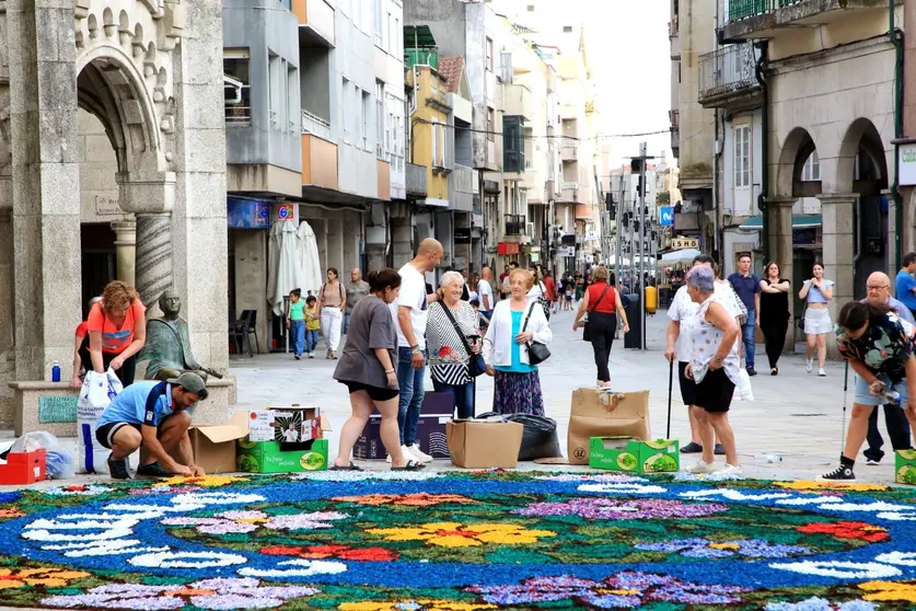 El arte efímero cobra vida en las calles de O Porriño: vecinos y voluntarios transforman pétalos y elementos naturales en impresionantes alfombras florales para el Corpus Christi.