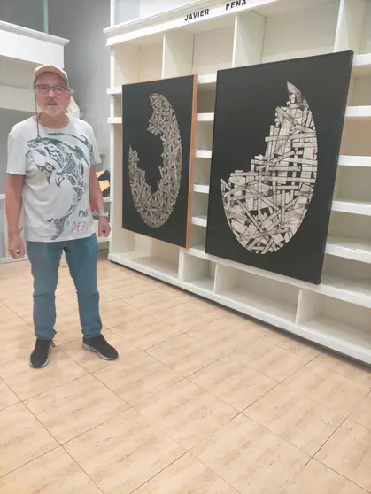 El artista Javier Pena posa ante sus obras de la serie 'Construcciones', que se exhiben en las Galerías Durán de Vigo.