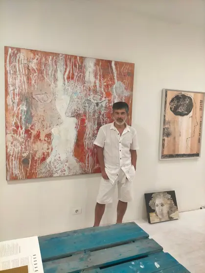 El artista Colin Baldwin junto a una de las obras de su serie "Línea Bruta", una exposición que reflexiona sobre la agitación interna en la era digital.