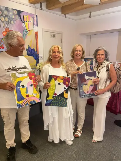 La pintora Carmen Touza con coleccionistas de sus obras en el 'Palacio Azul' de Braga.