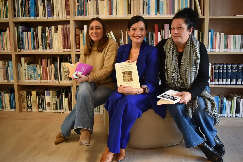 A alcaldesa de Mos, Nidia Arévalo, acompañada por dúas representantes municipais, durante a celebración do recoñecemento á Biblioteca María Magdalena.