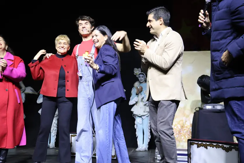 A alcaldesa de Mos, Nidia Arévalo, xunto ao director xeral de Comercio e Consumo, Gabriel Alén, e membros de Cantajuego durante o multitudinario acendido do Nadal no Pazo de Mos.