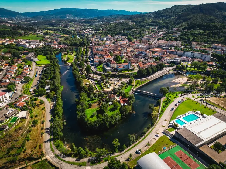 Vista a&eacute;rea de Arcos de Valdevez, com o centro urbano envolvido pelo rio Vez, evidenciando a integra&ccedil;&atilde;o entre patrim&oacute;nio, natureza e espa&ccedil;os de lazer no concelho.