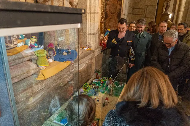 Asistentes a la inauguraci&oacute;n de la exposici&oacute;n 'Belenes del mundo' contemplan uno de los belenes expuestos en una de las vitrinas de la Catedral de Tui.
