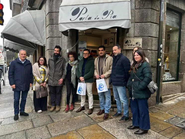 Foto de grupo diante de Porta da P&iacute;a, en Tui, durante a visita institucional para co&ntilde;ecer este proxecto representativo da artesan&iacute;a galega.