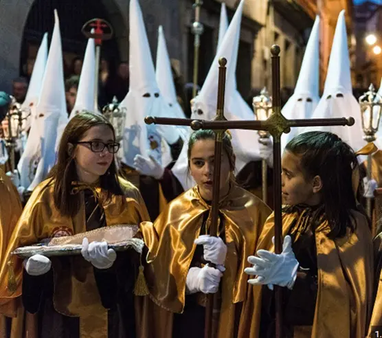 Miembros de una cofrad&iacute;a participan en una procesi&oacute;n de Semana Santa en Cangas, con los tradicionales h&aacute;bitos y estandartes recorriendo las calles del municipio.