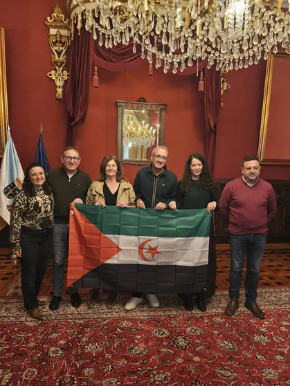 Representantes del Fondo Galego de Cooperaci&oacute;n e Solidariedade y del Concello de Santiago posan con la bandera saharaui durante la reuni&oacute;n de la Comisi&oacute;n Ejecutiva celebrada en la capital gallega.