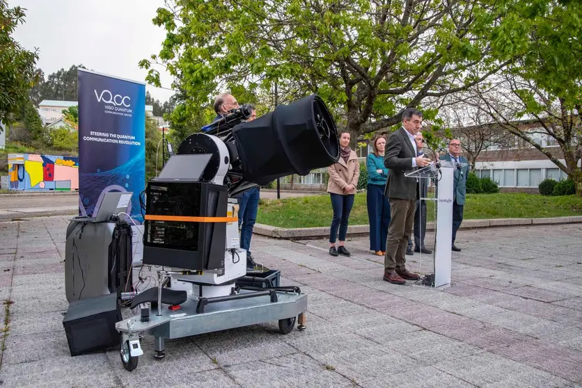 El conselleiro Rom&aacute;n Rodr&iacute;guez interviene durante la inauguraci&oacute;n de la infraestructura, junto al equipo investigador, con el sistema &oacute;ptico preparado para comunicaciones cu&aacute;nticas en primer plano.