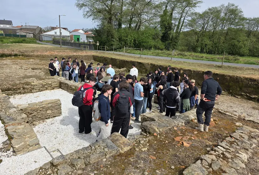 Estudantes do Grao en Historia seguen as explicaci&oacute;ns do equipo arqueol&oacute;xico nun percorrido polos restos romanos, evidenciando a magnitude do xacemento.