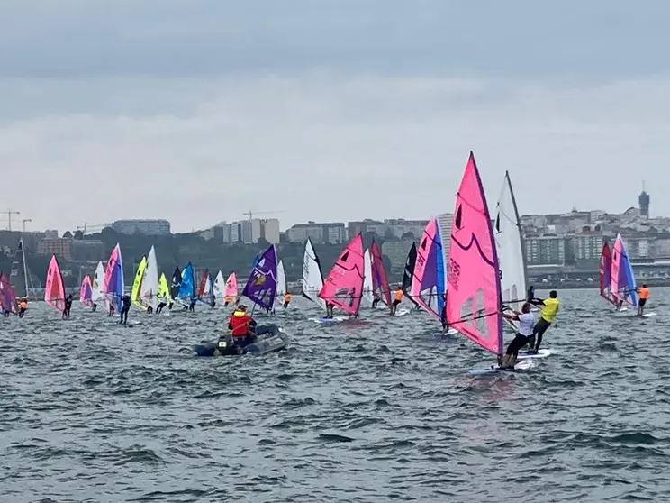 La flota de windsurfers, con velas multicolor, durante una de las mangas disputadas en la bah&iacute;a coru&ntilde;esa, en una jornada marcada por el viento variable y el mal tiempo.