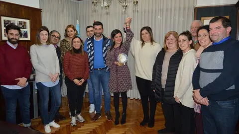 La alcaldesa mosense, Nidia Arévalo, levanta la mano de Rocío Blanco, entre autoridades y familiares en el salón de la Casa del Concello. 