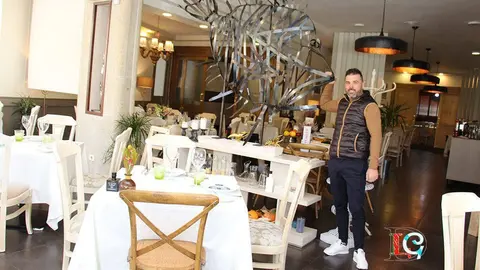Carlos Fernández, en el comedor de O Barazal, junto a la escultura de un pez de San Pedro. 