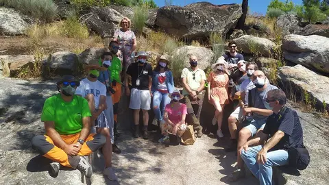 Participantes en el viaje de prensa organizado por el Concelho de Valpaços y los organizadores posando en un largar excavado en roca de época romana en Santa Valha. 