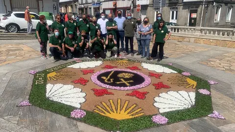 Los alfombristas posan ante el tapete floral. 