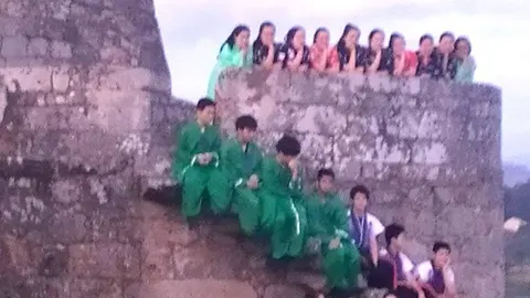Grupo folclórico extranjero posa en la muralla de Salvaterra. 