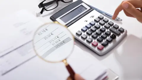 Photo Of Businesswoman Analyzing Invoice With Magnifying Glass