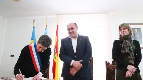 Horacio Gil y Nava Castro siguen la firma de Agnès Alfonso-Chariol, alcaldesa de Sainte Terre, en el libro de honor del Concello.